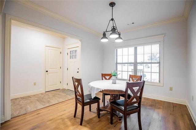 dining space featuring ornamental molding, an inviting chandelier, and wood-type flooring