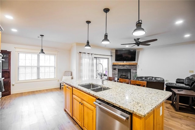 kitchen with sink, hanging light fixtures, dishwasher, and a fireplace