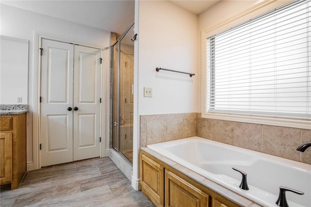 bathroom featuring plus walk in shower and vanity