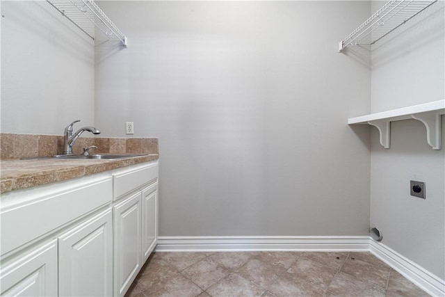 washroom with sink, cabinets, and hookup for an electric dryer