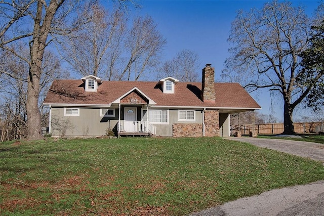 cape cod house featuring a front lawn and a carport