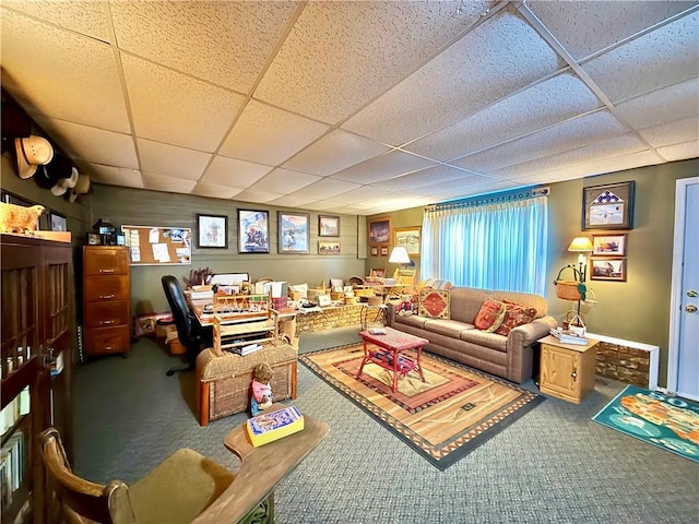 living room featuring a drop ceiling and carpet flooring