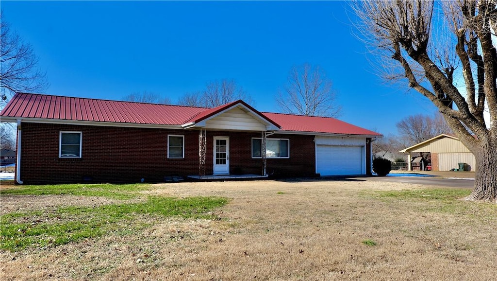 ranch-style house featuring a front yard, a garage, and a carport