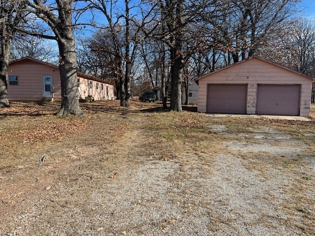 exterior space with a garage and an outbuilding