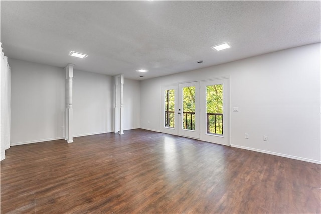 empty room featuring a textured ceiling and dark hardwood / wood-style flooring