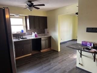 kitchen with tasteful backsplash, dark brown cabinets, dishwasher, and dark hardwood / wood-style flooring