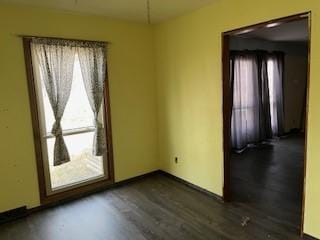 unfurnished room featuring dark wood-type flooring and plenty of natural light