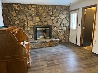 unfurnished living room with a fireplace and dark wood-type flooring