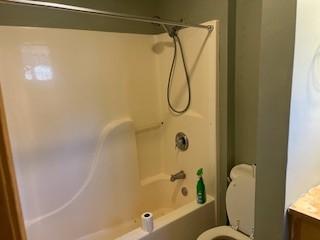 bathroom with toilet and shower / bathing tub combination