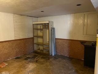 basement featuring wooden walls