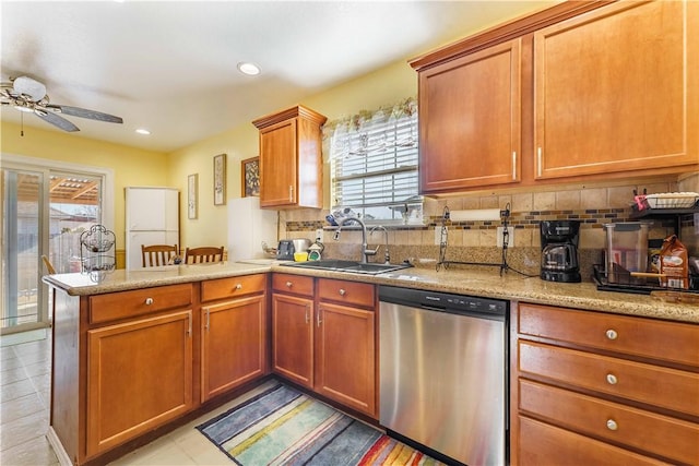 kitchen with dishwasher, light stone countertops, kitchen peninsula, ceiling fan, and sink