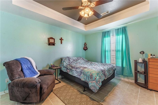 tiled bedroom with a raised ceiling, ceiling fan, and ornamental molding