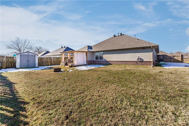 back of property with a yard, a storage unit, and a patio area