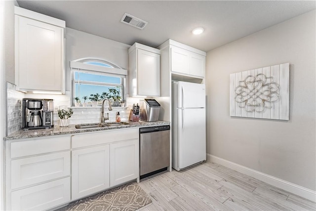 kitchen featuring sink, dishwasher, white cabinetry, and white fridge