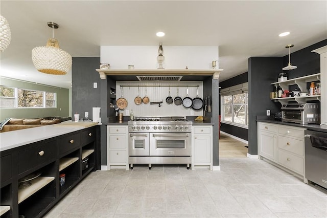 kitchen with appliances with stainless steel finishes, a healthy amount of sunlight, white cabinetry, and decorative light fixtures