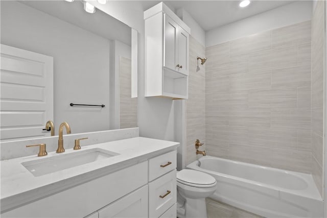 full bathroom featuring tiled shower / bath combo, vanity, and toilet