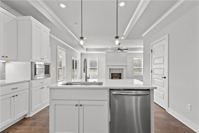 kitchen featuring stainless steel appliances, white cabinetry, sink, and a kitchen island with sink