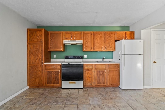 kitchen with sink, white appliances, and a textured ceiling