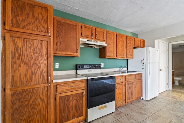 kitchen featuring white appliances, a textured ceiling, light tile patterned floors, and sink