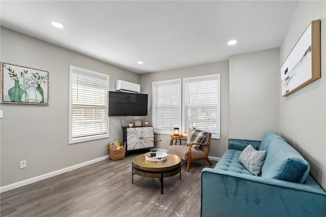 living area featuring wood-type flooring, a wealth of natural light, and a wall mounted air conditioner