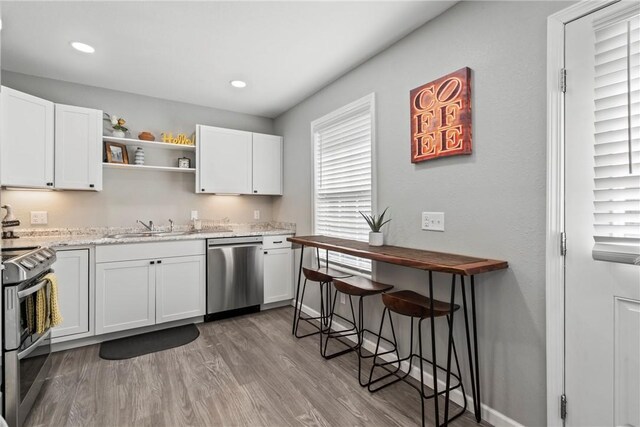 kitchen featuring stainless steel appliances, light wood-type flooring, white cabinets, and sink