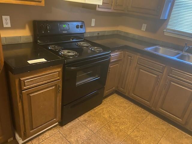 kitchen with sink, electric range, and light tile patterned floors