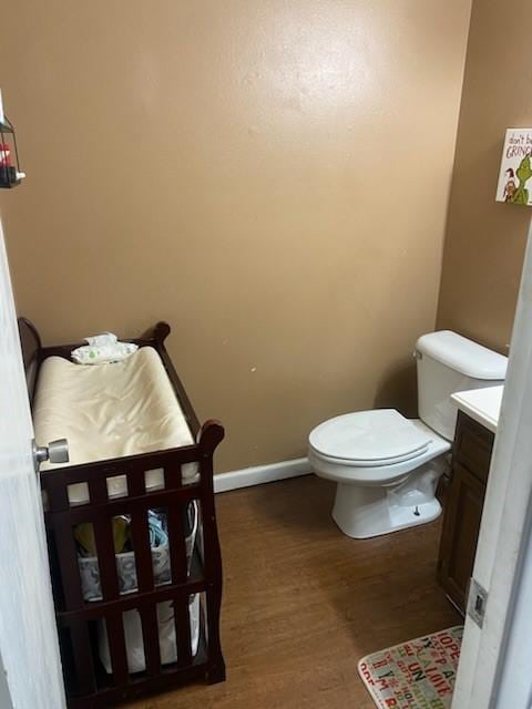 bathroom featuring toilet, vanity, and wood-type flooring