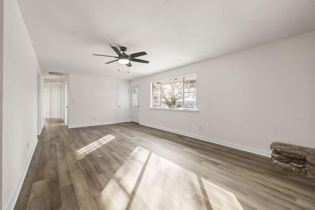 unfurnished room with ceiling fan and dark wood-type flooring