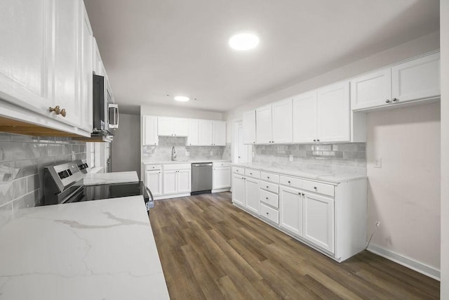 kitchen featuring stainless steel appliances, light stone counters, dark hardwood / wood-style floors, sink, and white cabinetry