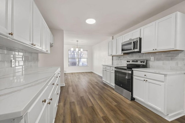 kitchen featuring appliances with stainless steel finishes, hanging light fixtures, white cabinets, and decorative backsplash