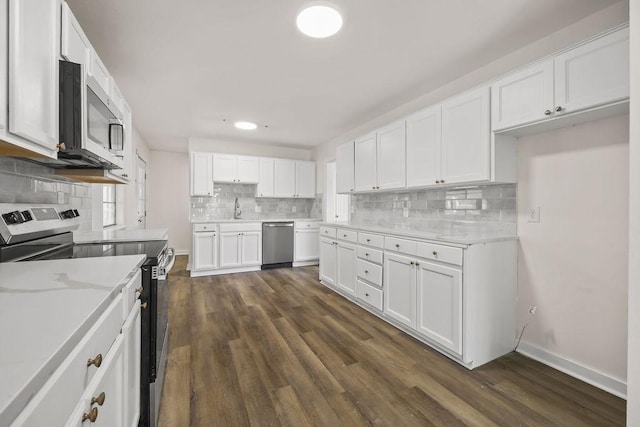 kitchen with stainless steel appliances, dark wood-type flooring, decorative backsplash, white cabinets, and sink