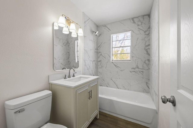 full bathroom featuring toilet, wood-type flooring, vanity, and tiled shower / bath