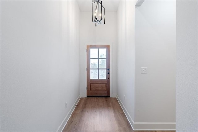 doorway to outside featuring light hardwood / wood-style flooring and a chandelier