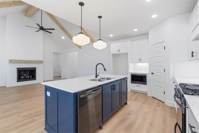 kitchen featuring stainless steel appliances, beam ceiling, white cabinetry, and sink