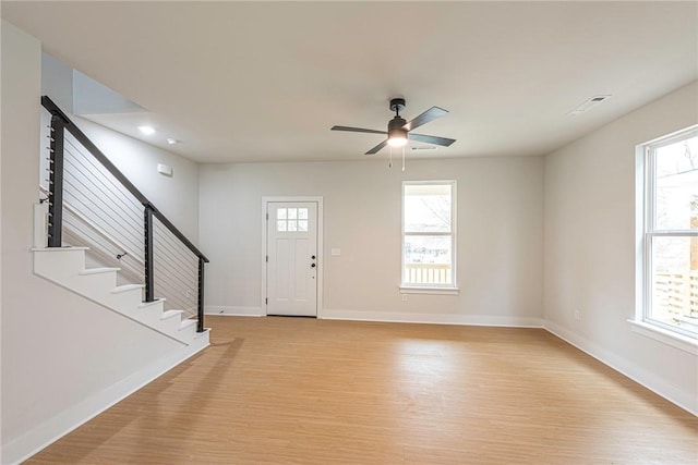 entrance foyer featuring light wood-style floors, stairway, and baseboards