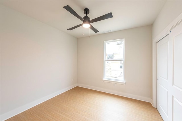 unfurnished bedroom with a ceiling fan, baseboards, visible vents, and light wood finished floors