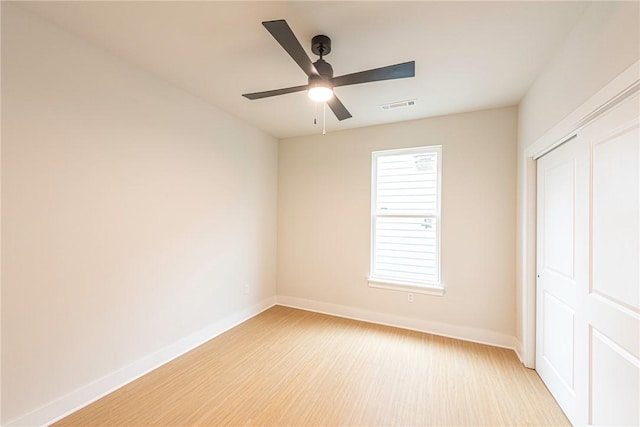 unfurnished bedroom featuring baseboards, visible vents, ceiling fan, light wood-type flooring, and a closet