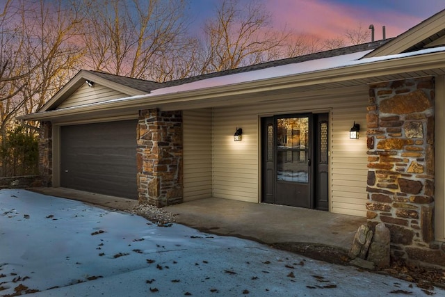 exterior space featuring covered porch, stone siding, and an attached garage