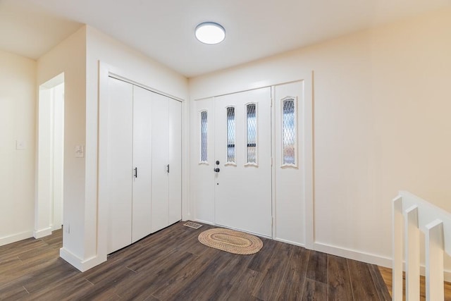 entrance foyer featuring dark wood finished floors and baseboards