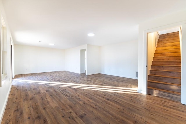 empty room with stairs, recessed lighting, wood finished floors, and baseboards