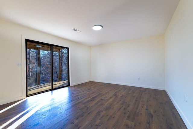 empty room featuring dark wood-type flooring and baseboards