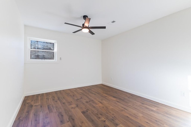 unfurnished room featuring ceiling fan, wood finished floors, visible vents, and baseboards