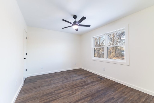 unfurnished room featuring a ceiling fan, dark wood-style flooring, and baseboards