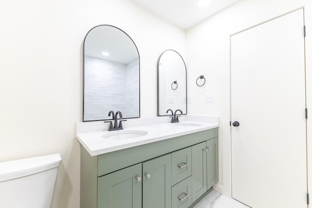 full bathroom with marble finish floor, a sink, toilet, and double vanity