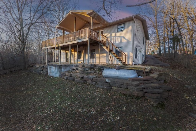 rear view of property with stairs and a wooden deck