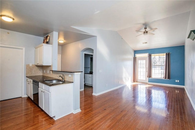 kitchen with hardwood / wood-style floors, decorative backsplash, white cabinets, lofted ceiling, and sink