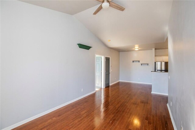 spare room with ceiling fan, vaulted ceiling, and dark hardwood / wood-style floors