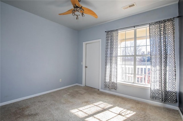 unfurnished room featuring carpet flooring, ceiling fan, and a wealth of natural light