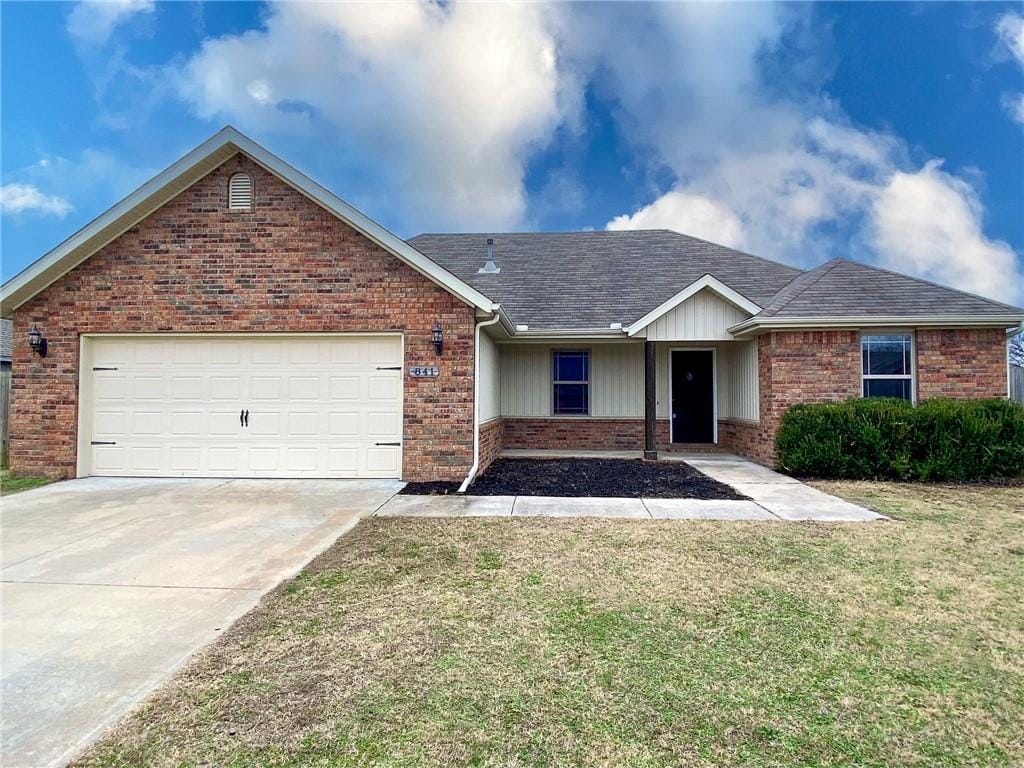 single story home with a front yard and a garage