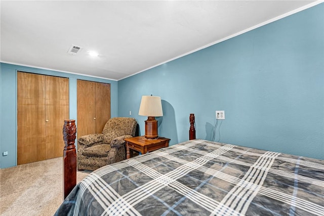 bedroom featuring carpet, multiple closets, and crown molding